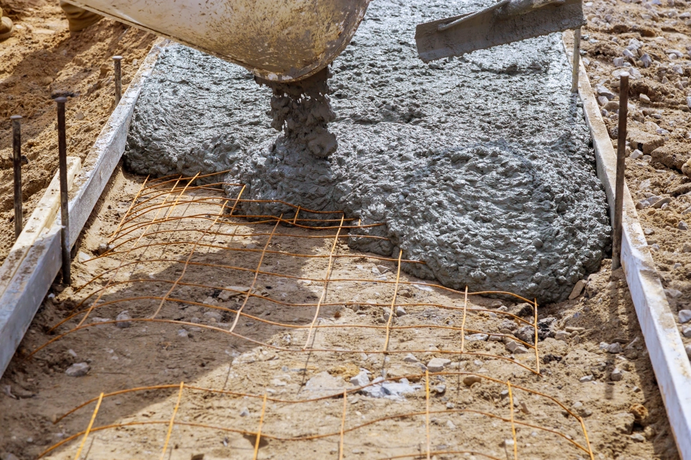 Wylewanie betonu na metalową siatkę zbrojeniową jako wylewki samopoziomujące pod posadzkę