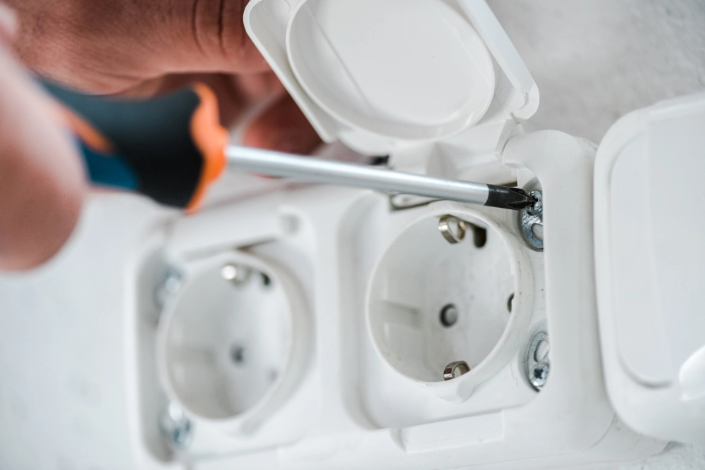 Montaż gniazda elektrycznego w ścianie przy użyciu śrubokręta – instalacje elektryczne